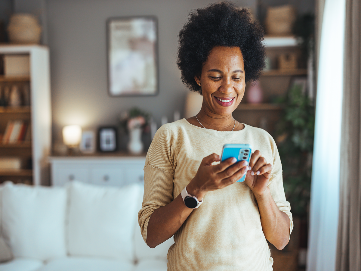 Woman using a phone in a cozy interior space
