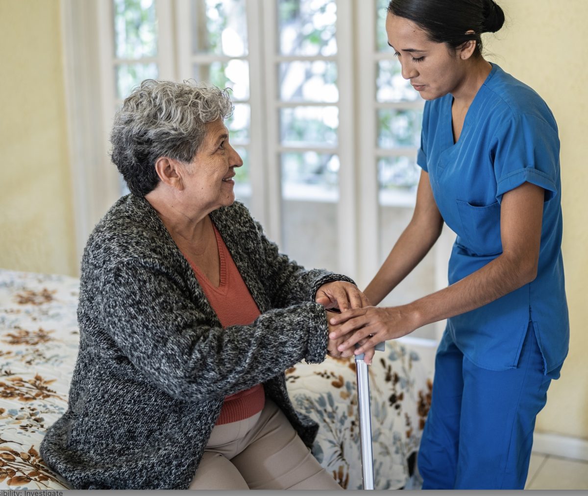 A caregiver assisting a resident in a bright room