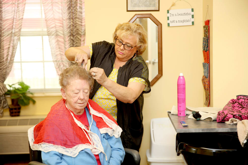 A resident receiving a hairstyle in a salon setting