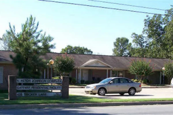 Exterior view of the facility with a sign and a parked car