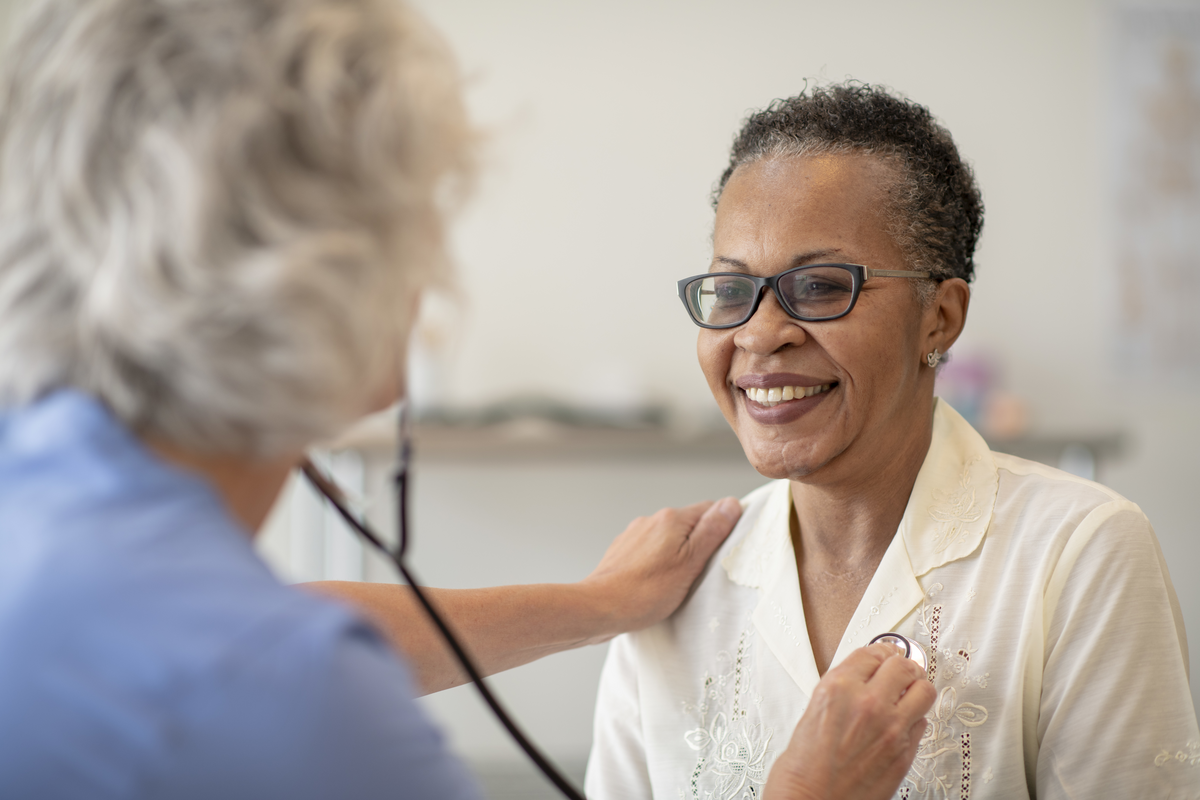 Healthcare worker listening to a resident's heartbeat