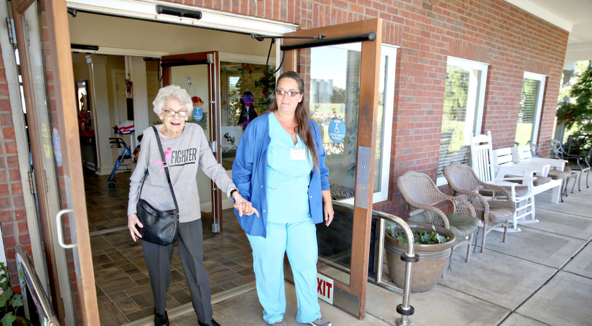 Resident and staff leaving the facility entrance together
