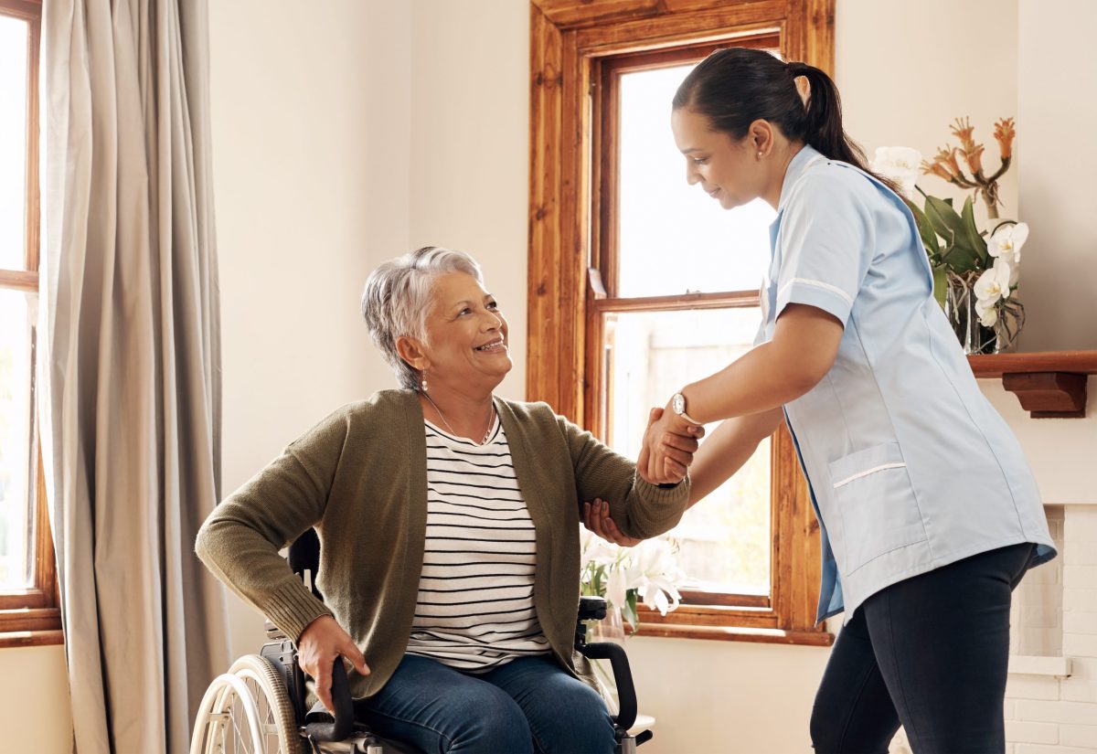 A caregiver assisting a resident in a bright room