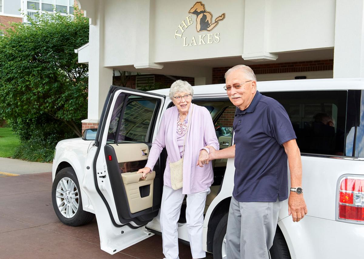 Residents being assisted into a facility vehicle