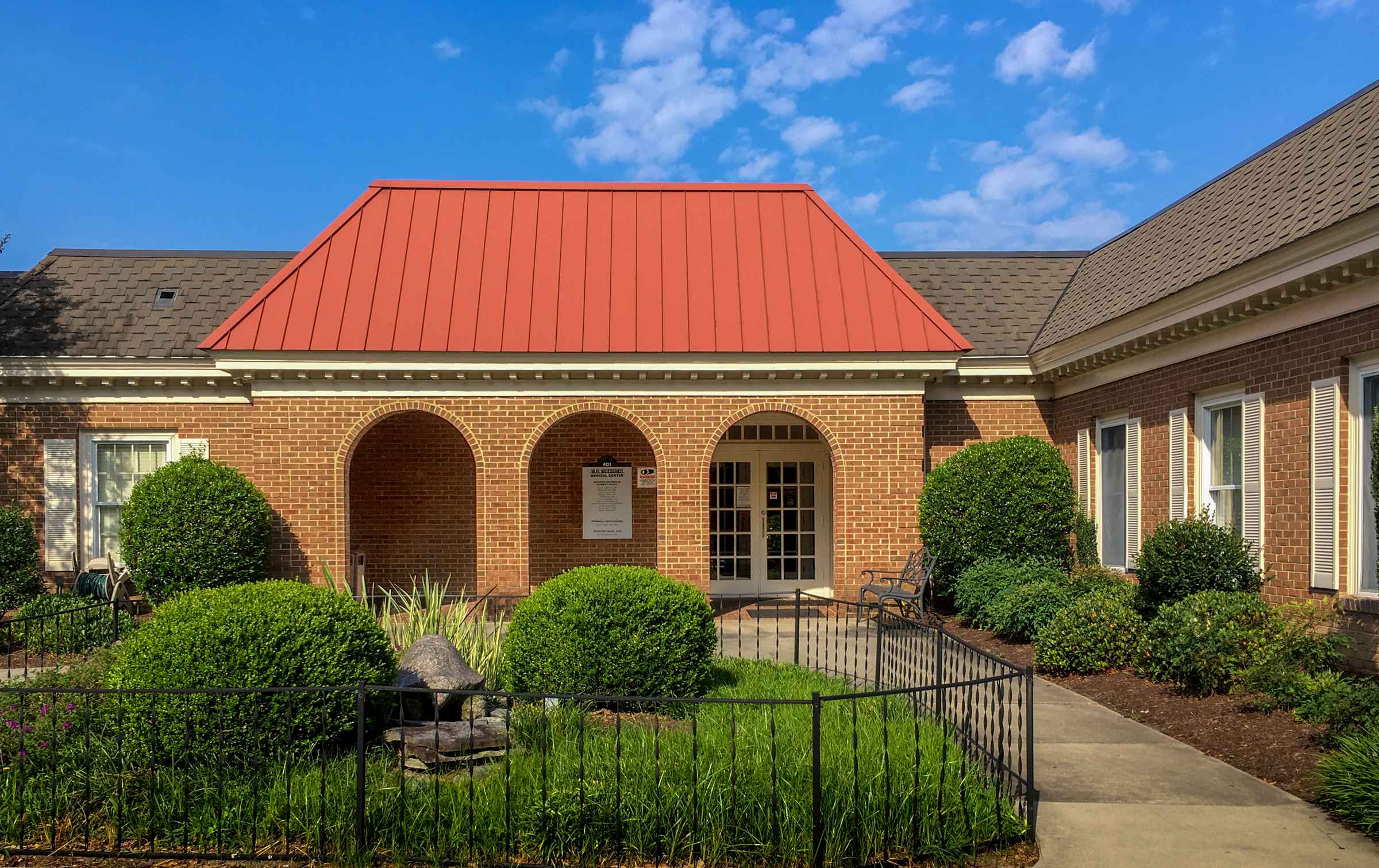Building exterior with landscaping and red roof