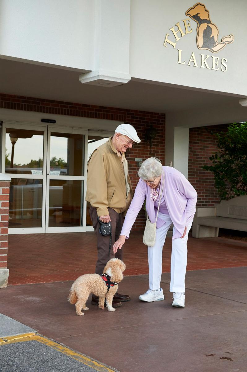 Couple interacting with a dog outside the facility