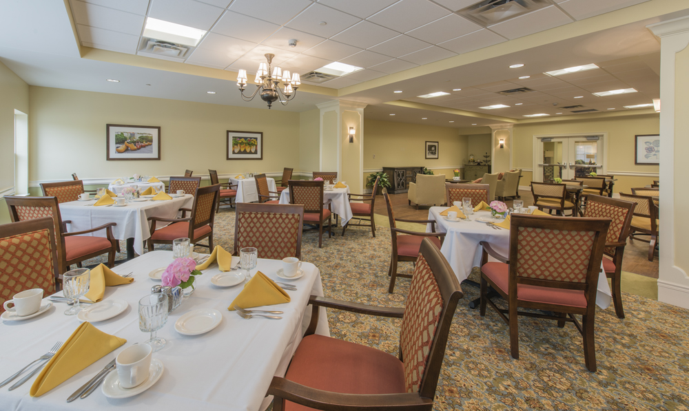 Dining room set up for a meal with flowers on the tables