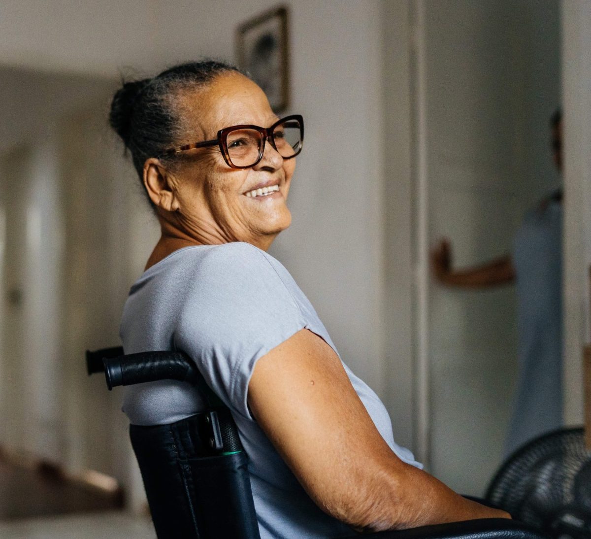 A smiling resident in a wheelchair in a bright room