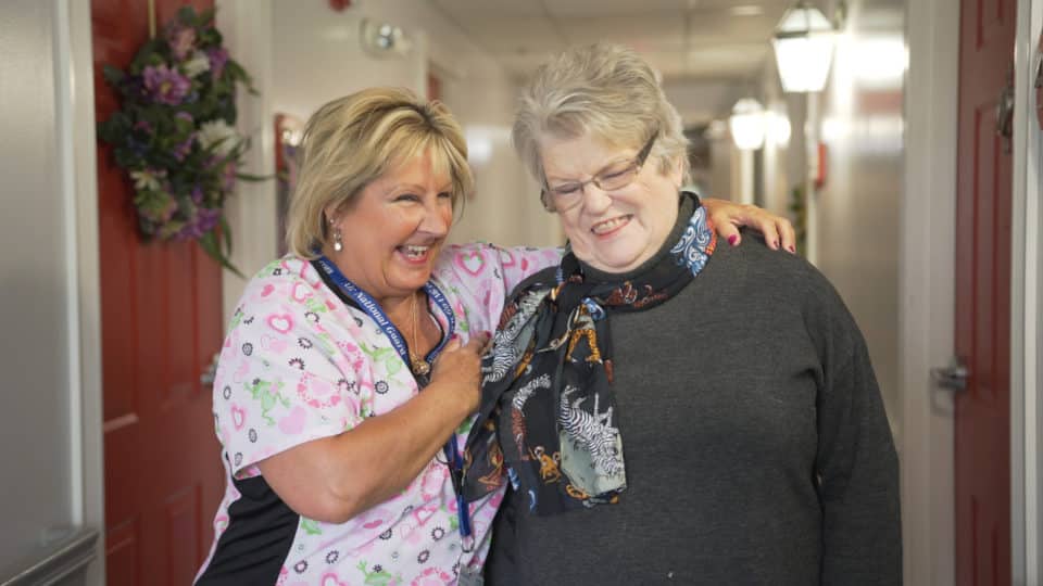 Staff member engaging with a resident in a hallway