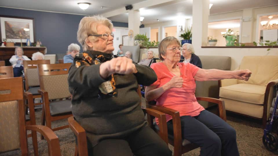 Residents participating in an exercise group in the activity room