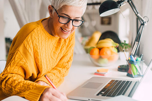 Senior woman engaging in creative activities at a desk