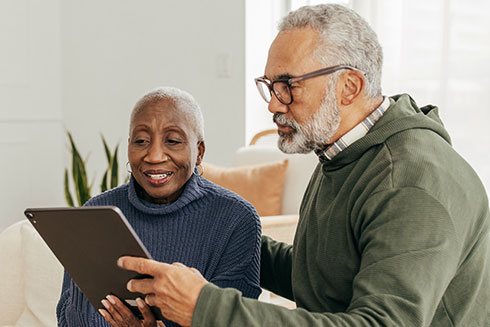 Residents engaging with a tablet in a cozy interior