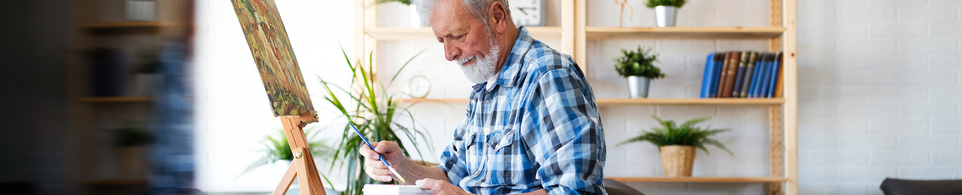 An elderly man painting in a common area