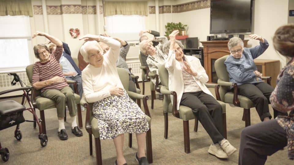 Residents participating in a seated exercise class