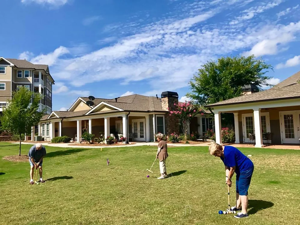 Residents playing croquet in a sunny outdoor area