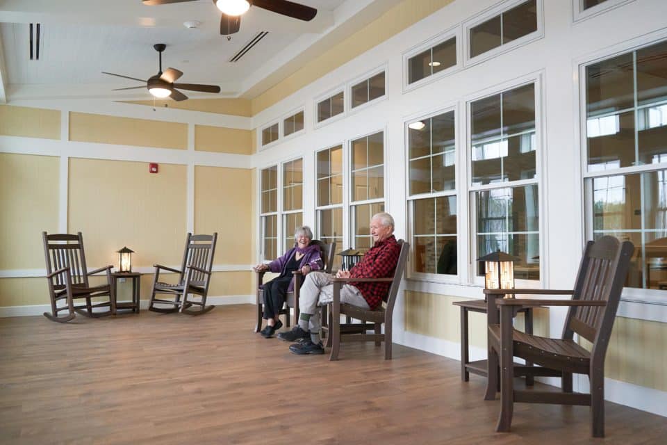 Residents relaxing in a common area with rocking chairs
