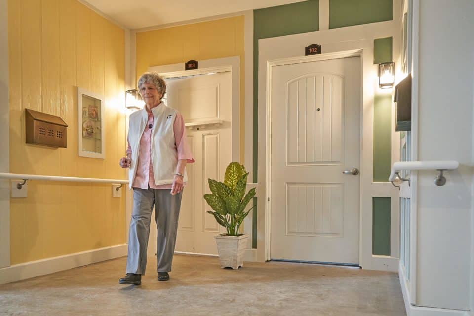 Resident walking in a well-lit interior hallway