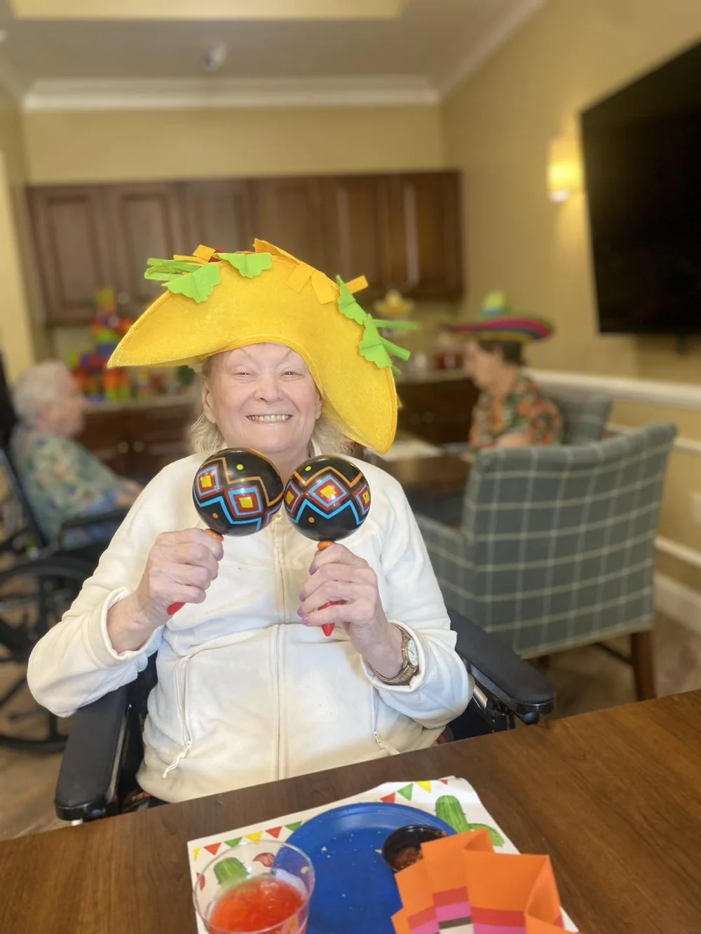 Resident participating in a festive activity with maracas