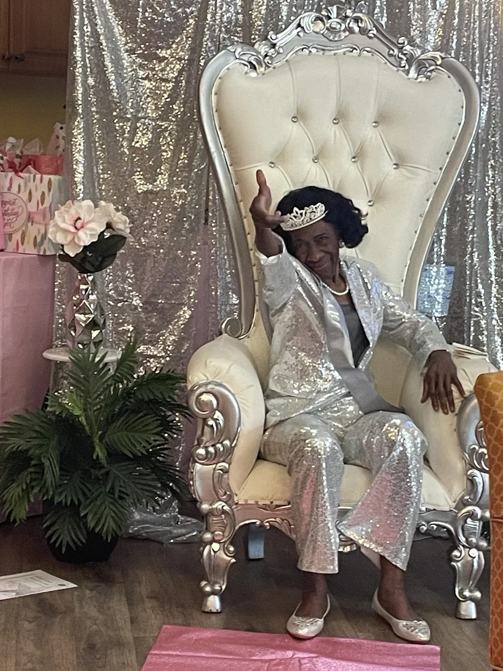 A resident dressed in silver seated on a throne chair