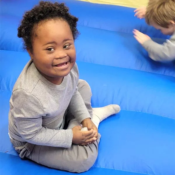 Child sitting on a blue inflatable surface