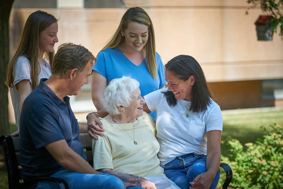 Family interacting with a resident in a garden