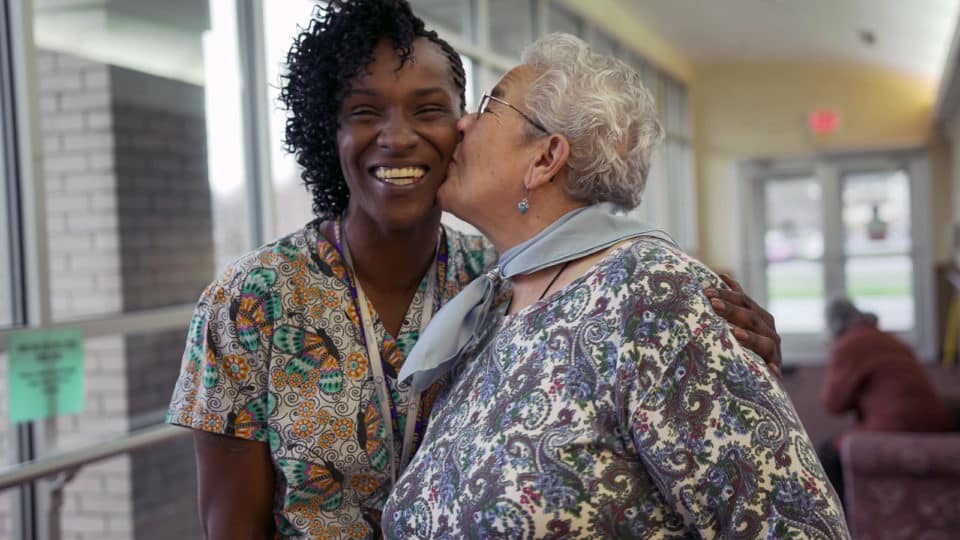 Care staff and resident sharing a joyful moment