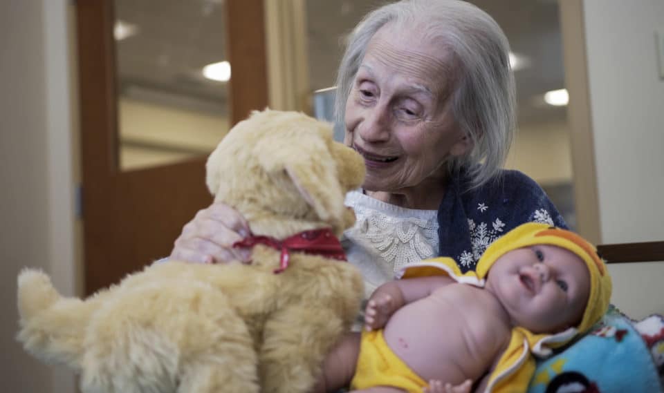 Resident interacting with stuffed animals in a warm atmosphere.