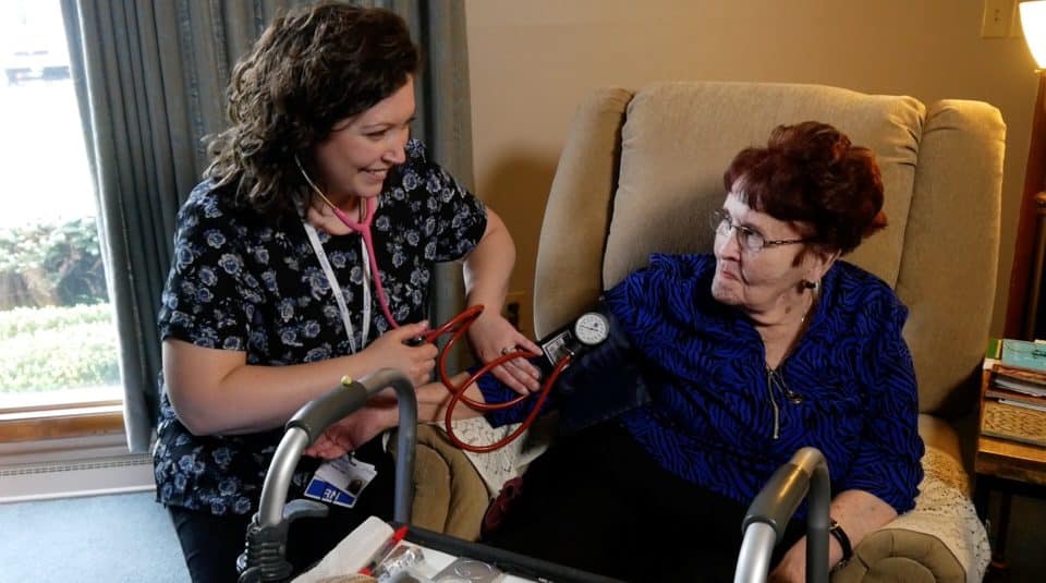 Caregiver checking blood pressure of a resident