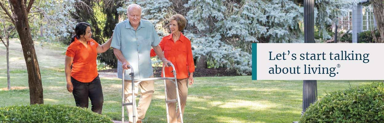 Residents walking in the garden with caregivers