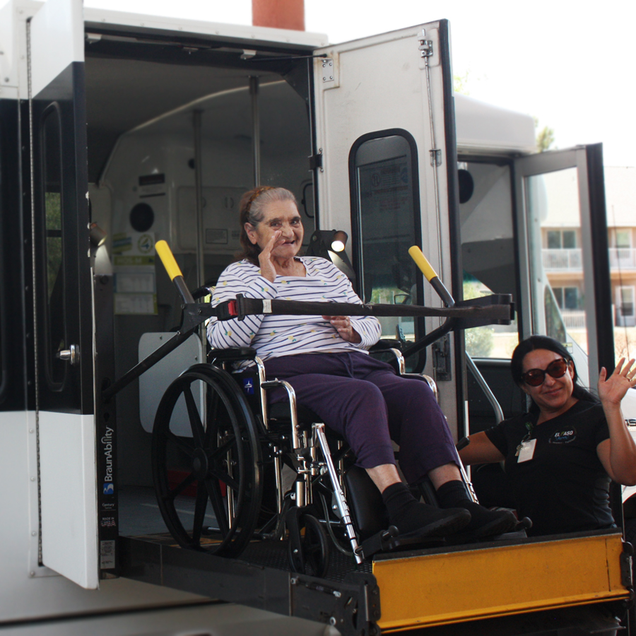 Resident exiting from a facility vehicle with staff assistance.
