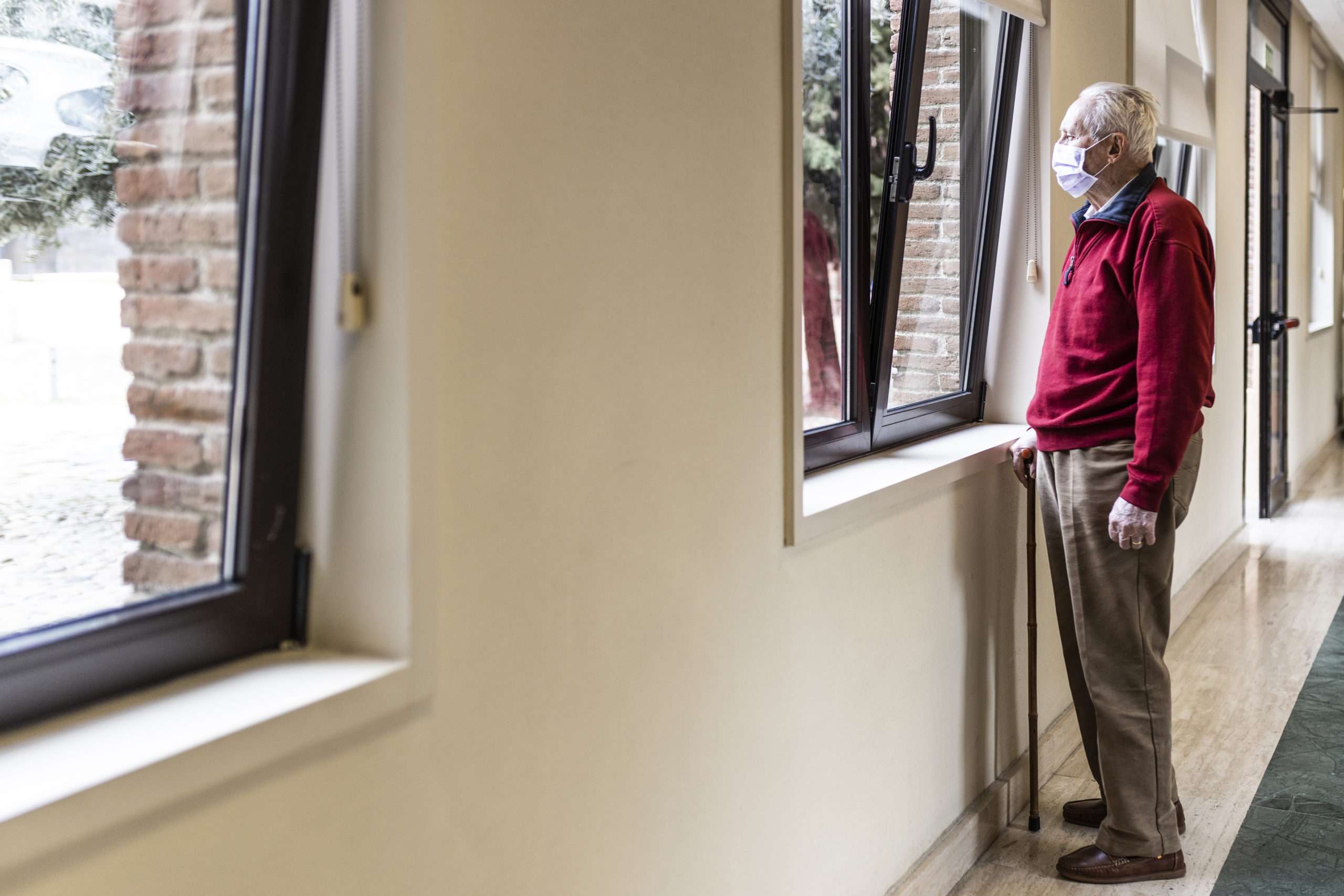 Senior man looking out of a window