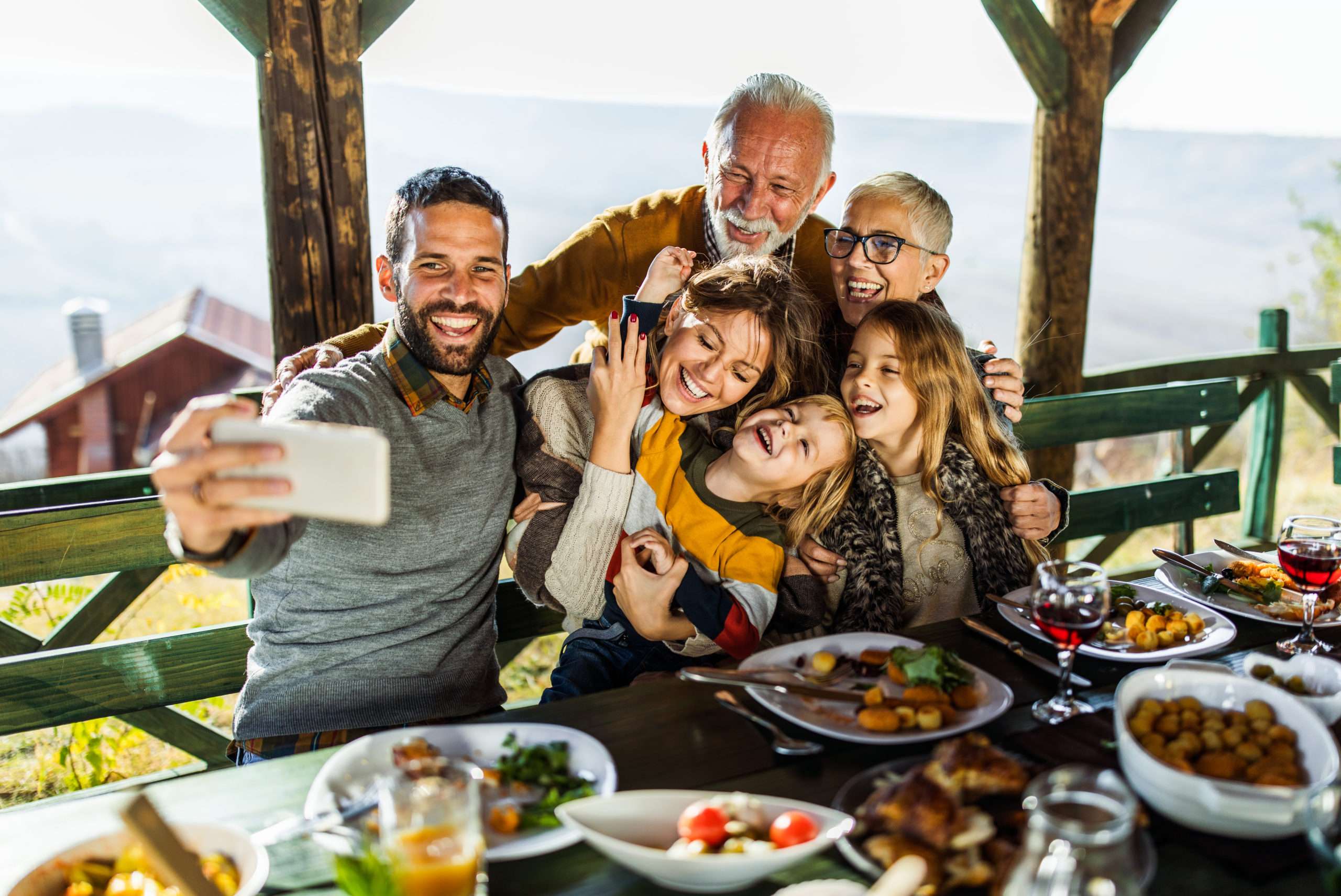 Family gathering outdoors enjoying a meal together
