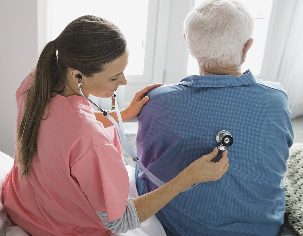 Nurse assisting a senior resident with a stethoscope