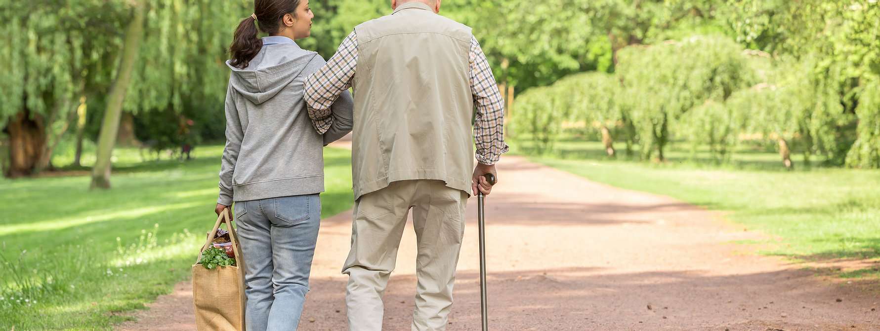 Caregiver walking with a resident in a park