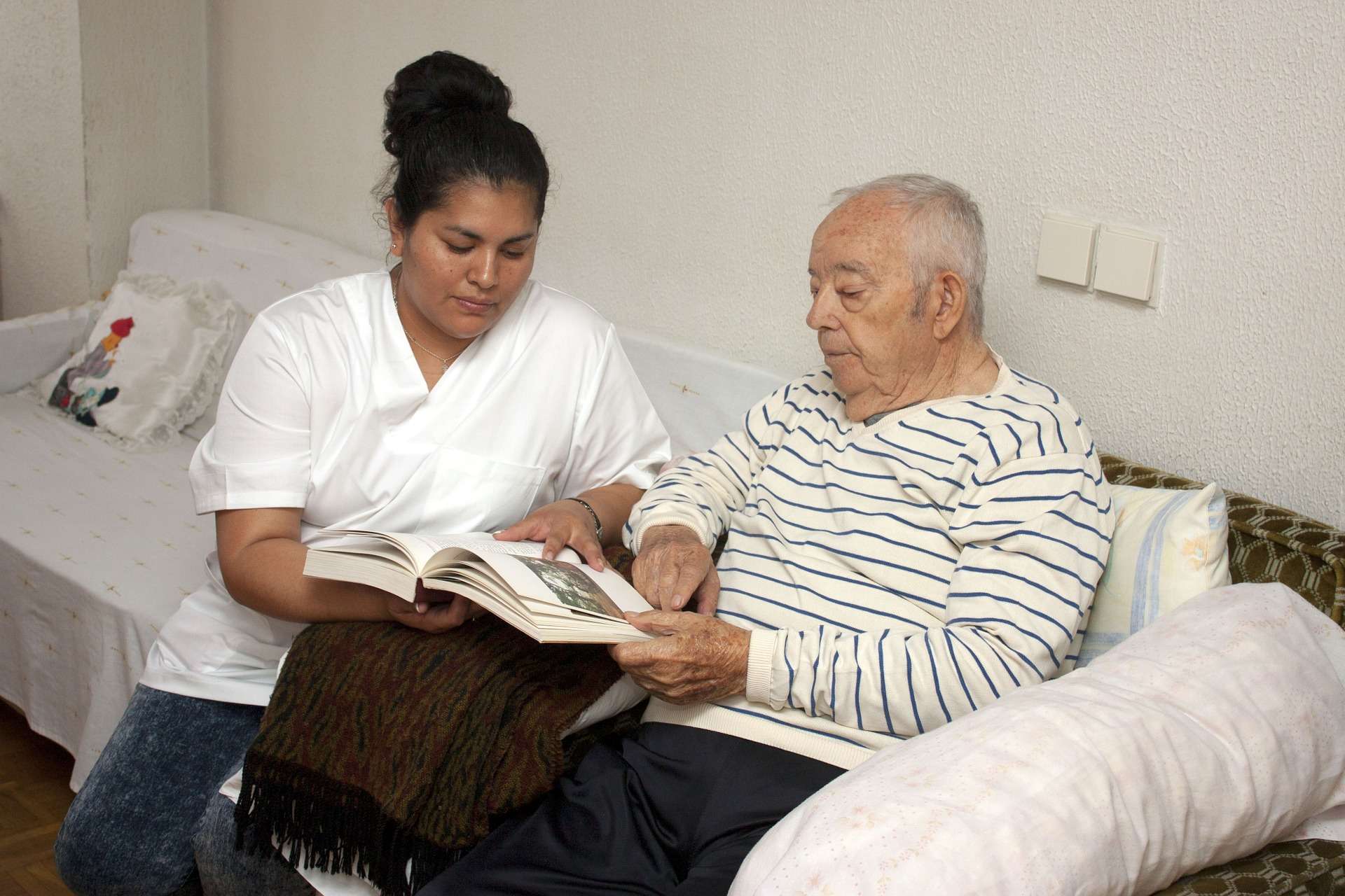 Caregiver reading with an elderly resident