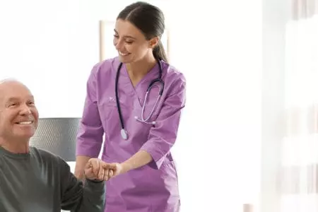 Healthcare worker assisting an elderly man.