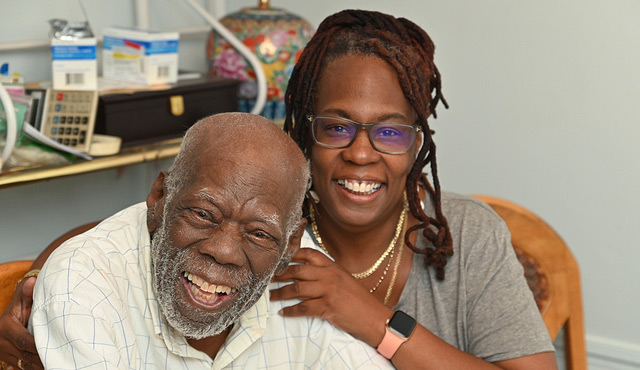 Elderly man smiling with a caregiver in a welcoming interior