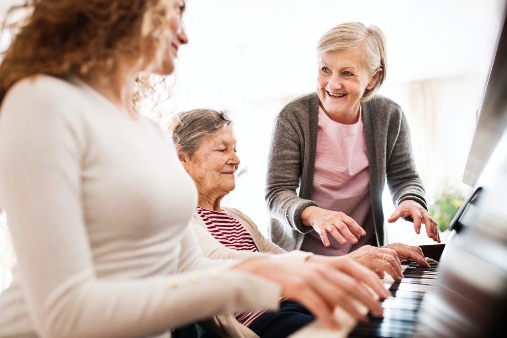 Residents and staff enjoying a music activity at the piano.
