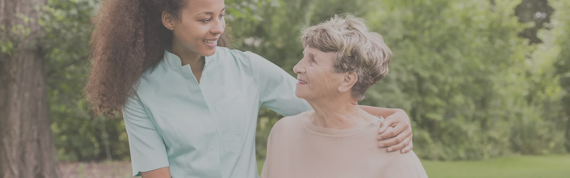 Caregiver assisting a senior outdoors.