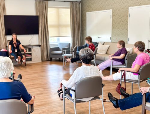 Residents participating in a seated exercise class