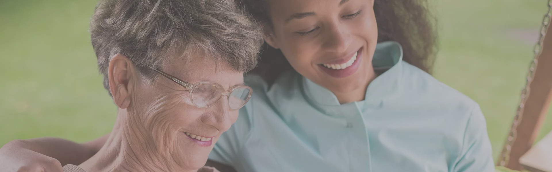 Smiling elderly woman with caregiver outdoors