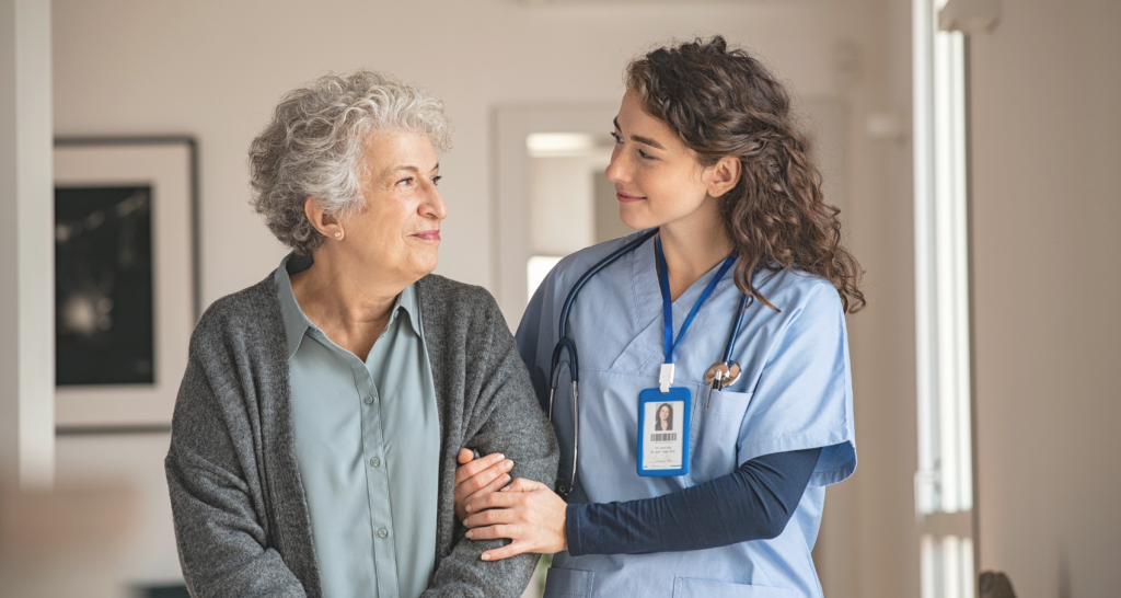 Caregiver interacting with elderly resident indoors.