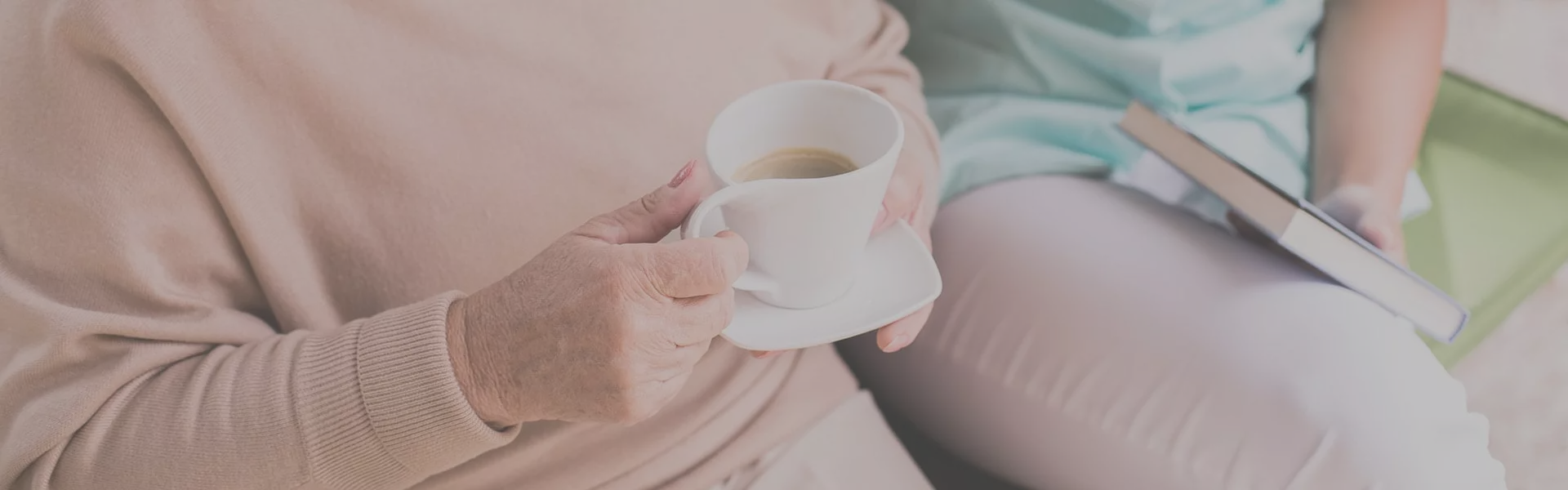 An elderly woman holding a cup of coffee