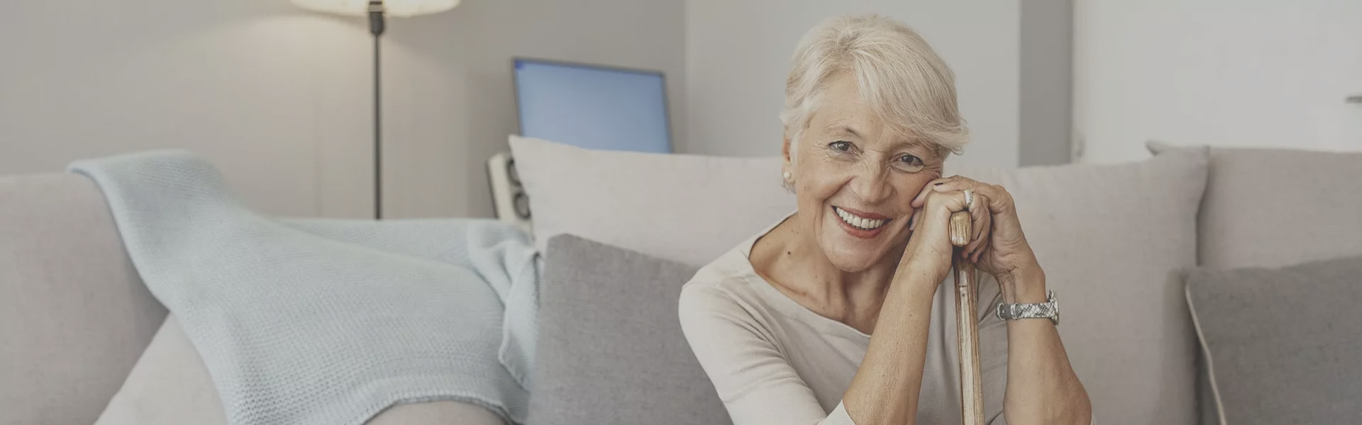 Smiling elderly woman in a cozy interior.