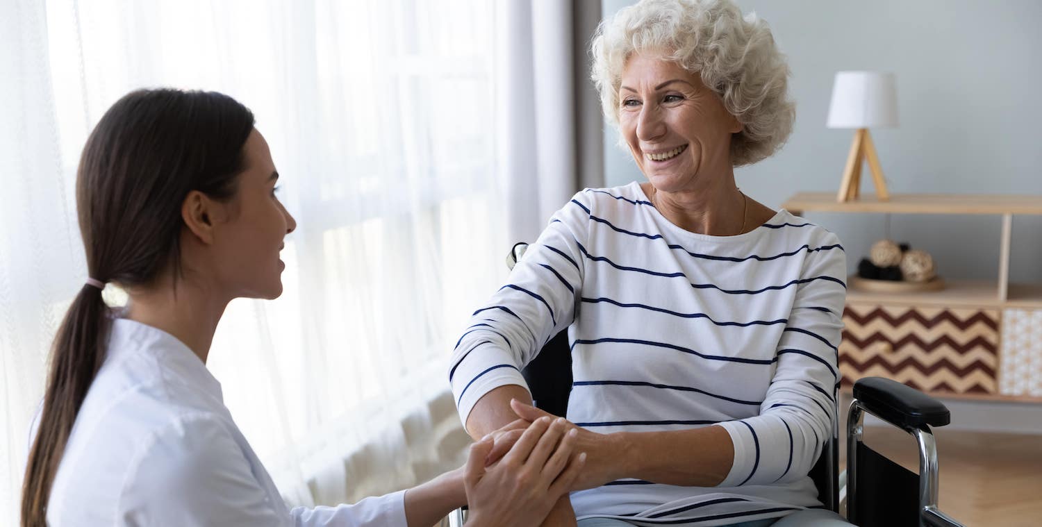 Caregiver assists a resident in a warm setting.