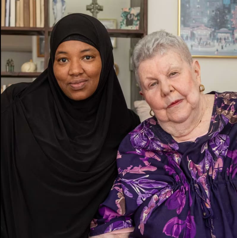 A caregiver and a resident posing together