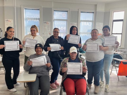 Residents showcasing certificates in a common area