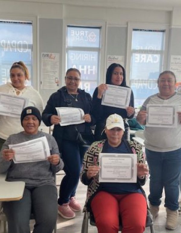 Residents celebrating with certificates in a classroom setting.