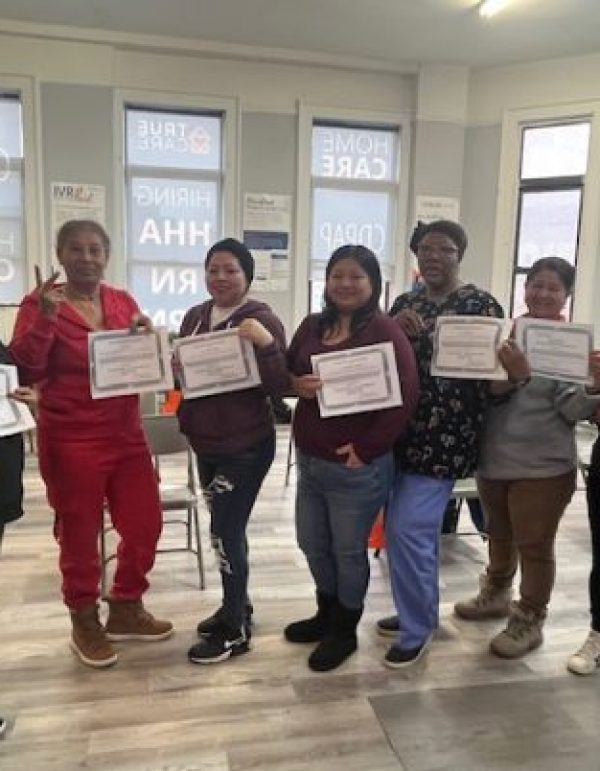Staff members holding certificates in a common area