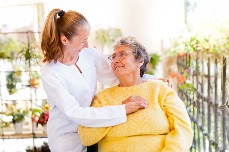 Caregiver interacting with a senior resident outdoors